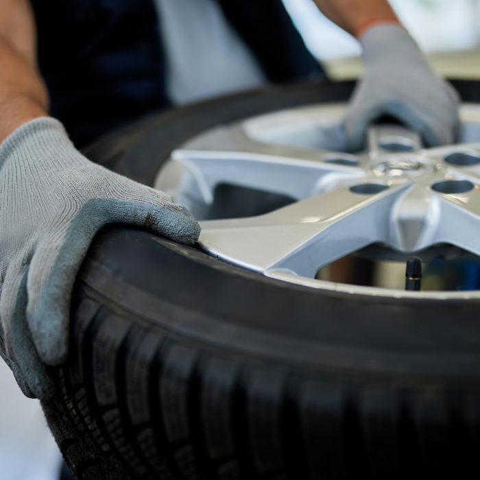Close-up of a mechanic working with car tire in auto repair shop