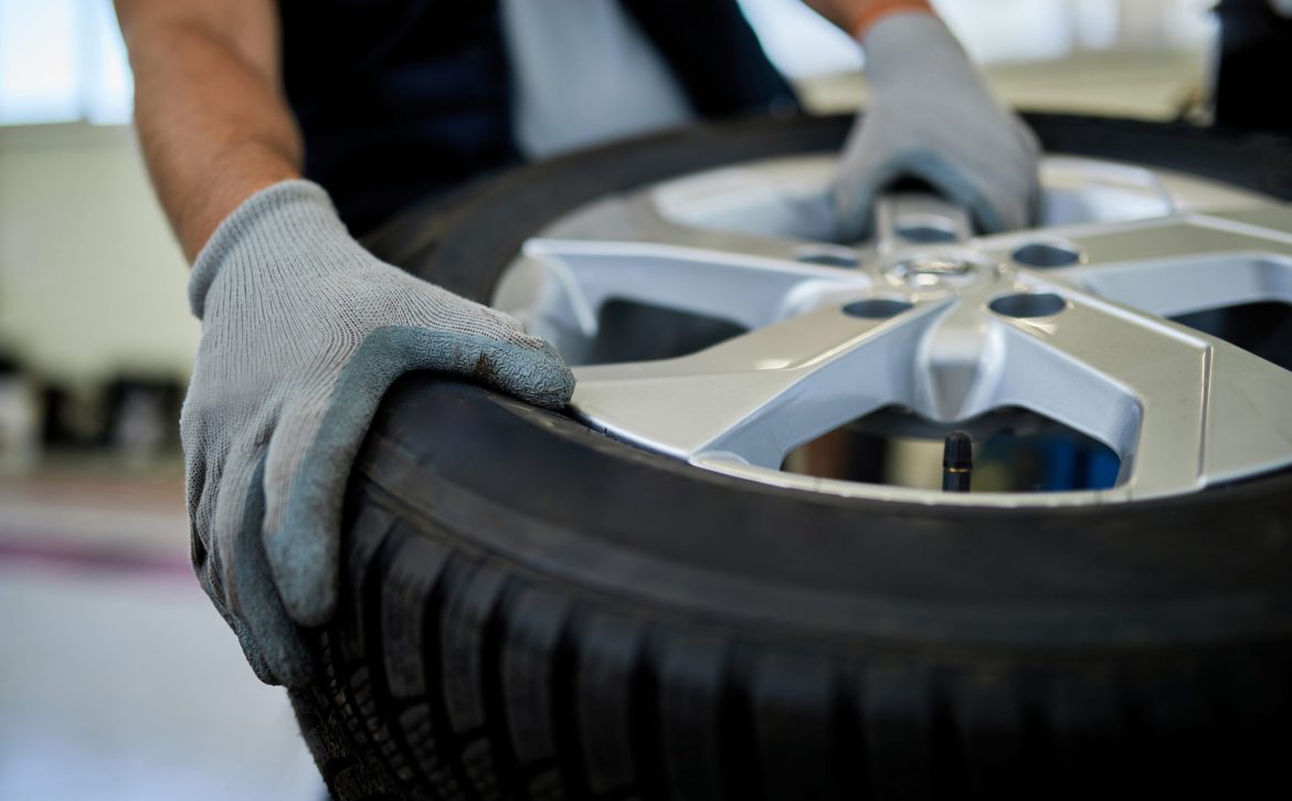 Close-up of a mechanic working with car tire in auto repair shop